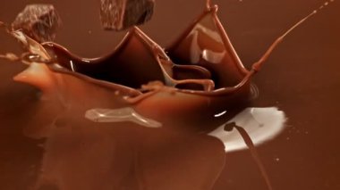 Süper yavaş çekimde siyah çikolata parçaları sıvı çikolatanın içine düşer. 1000 fps 'de yüksek hızlı bir kamerayla çekildi. Yüksek kaliteli FullHD görüntüler