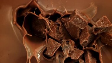 Süper yavaş çekimde siyah çikolata parçaları sıvı çikolatanın içine düşer. 1000 fps 'de yüksek hızlı bir kamerayla çekildi. Yüksek kaliteli FullHD görüntüler