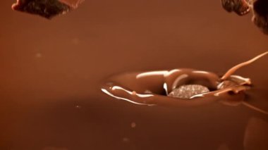 Süper yavaş çekimde siyah çikolata parçaları sıvı çikolatanın içine düşer. 1000 fps 'de yüksek hızlı bir kamerayla çekildi. Yüksek kaliteli FullHD görüntüler