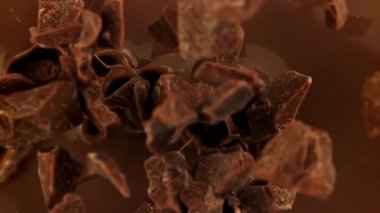 Süper yavaş çekimde siyah çikolata parçaları sıvı çikolatanın içine düşer. 1000 fps 'de yüksek hızlı bir kamerayla çekildi. Yüksek kaliteli FullHD görüntüler