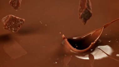 Süper yavaş çekimde siyah çikolata parçaları sıvı çikolatanın içine düşer. 1000 fps 'de yüksek hızlı bir kamerayla çekildi. Yüksek kaliteli FullHD görüntüler