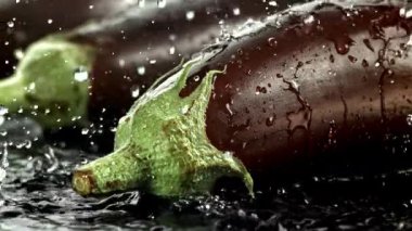 Süper yavaş çekim taze patlıcan, su sıçraması ve damla damla. 1000 fps 'de yüksek hızlı bir kamerayla çekildi. Yüksek kaliteli FullHD görüntüler
