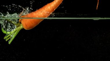 Süper yavaş çekimde taze havuç. 1000 fps 'de yüksek hızlı bir kamerayla çekildi. Yüksek kaliteli FullHD görüntüler