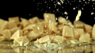 Süper yavaş çekimde beyaz çikolata parçaları. 1000 fps 'de yüksek hızlı bir kamerayla çekildi. Yüksek kaliteli FullHD görüntüler