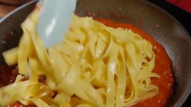 Kızartma tavasına bolonez soslu Tagliatelle makarnası ekleniyor.