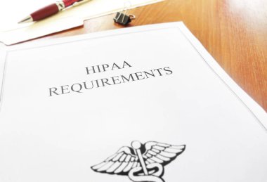HIPAA healthcare requirements document on an office desk  clipart