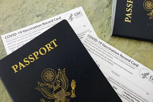 US passport with COVID-19 Vaccination Record Cards, issued by the United States CDC to indicate an individial has been vaccinated against the Coronavirus