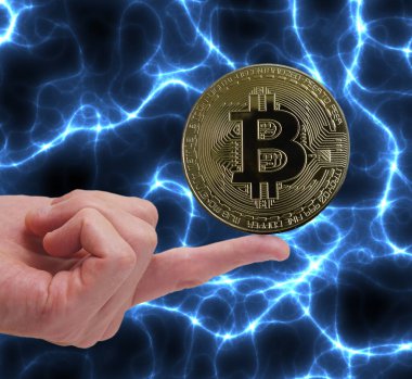 Bitcoin kripto para mavi enerji arka planına sahip bir parmak üzerinde dengeleniyor