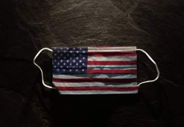 Koyu arka planda cerrahi Amerikan bayrağı maskesi -- USA Coronavirus konsepti                            
