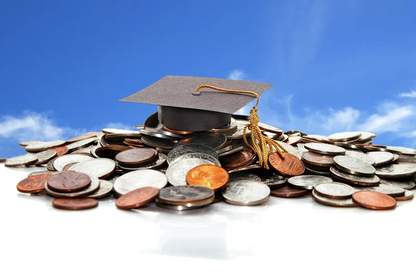 Graduation cap on a pile of coins — Stock Photo, Image