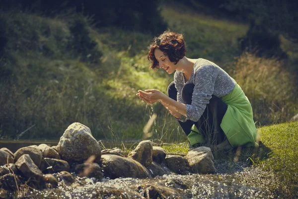 Mujer lavándose las manos en agua corriente de montaña —  Fotos de Stock