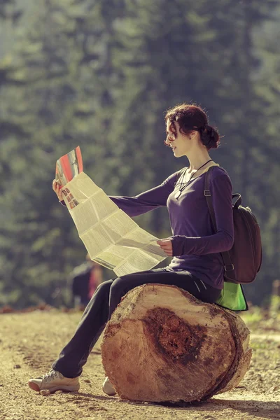 Young woman reading travel map