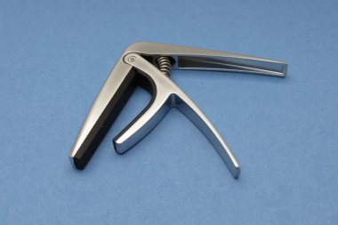 Açık mavi renkli bir gitar boyun uyacak bir capo