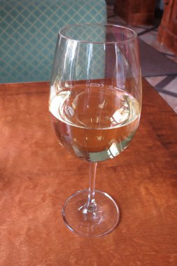 Restoran masasında bir bardak beyaz şarap.