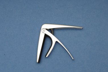 Açık mavi renkli bir gitar boyun uyacak bir capo