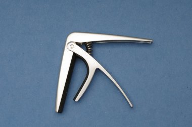 Açık mavi renkli bir gitar boyun uyacak bir capo