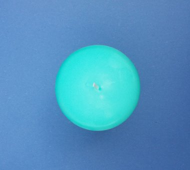 Açık mavi arka planı üzerinde yeşil mavi mum