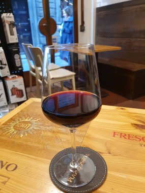 FLORENCE, ITALY - 10 Nisan 2025: bir şarap barında bir bardak kırmızı şarap