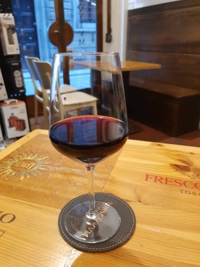 FLORENCE, ITALY - 10 Nisan 2025: bir şarap barında bir bardak kırmızı şarap