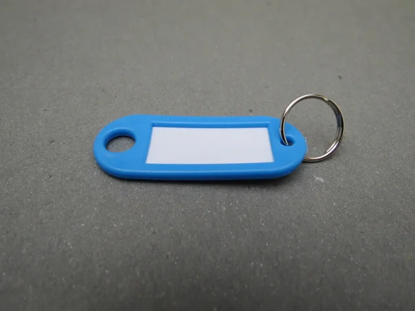 Porte Clés Plastique Bleu Avec Étiquette Sur Fond Gris — Photo