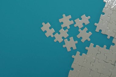 Mavi arkaplanda beyaz yapboz parçaları