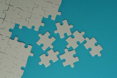 Mavi arkaplanda beyaz yapboz parçaları