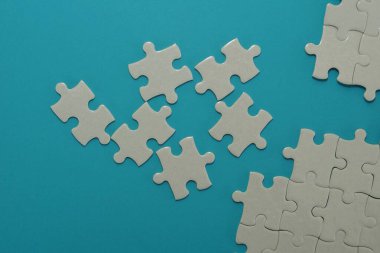 Mavi arkaplanda beyaz yapboz parçaları