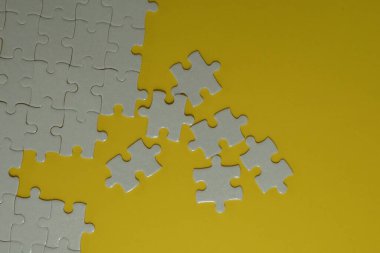 Sarı arkaplanda beyaz yapboz parçaları
