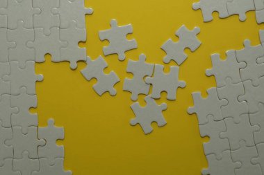 Sarı arkaplanda beyaz yapboz parçaları