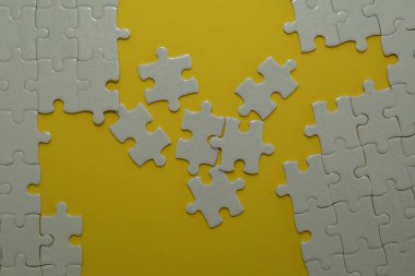 Sarı arkaplanda beyaz yapboz parçaları