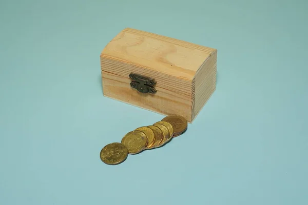装有蓝色背景孤立硬币的木盒 — 图库照片