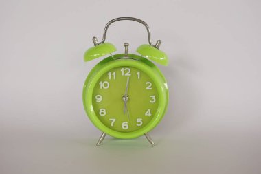 Beyaz arkaplanda yeşil alarm saati izole edildi