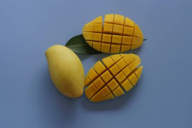 Mavi arka planda doğranmış mango meyveleri