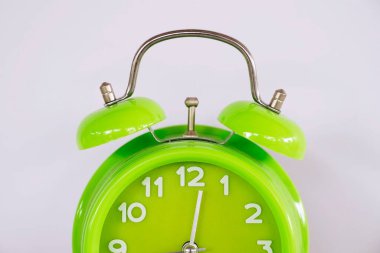 Beyaz arkaplanda yeşil alarm saati izole edildi