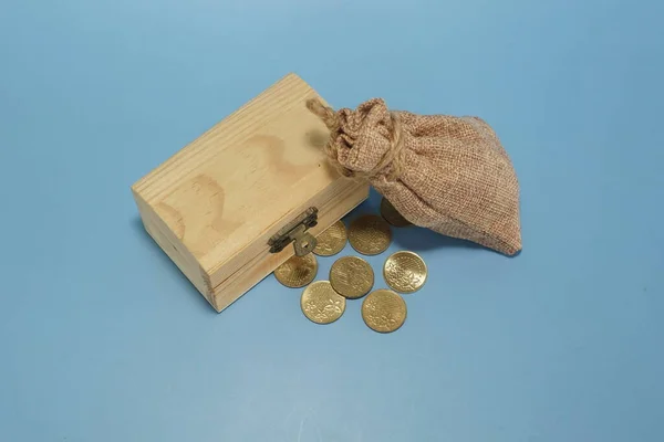 蓝底木盒和袋装硬币 — 图库照片