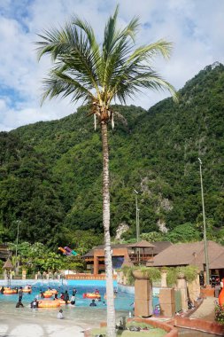 İnsanlar yeşil dağın altında gün ışığında havuzda