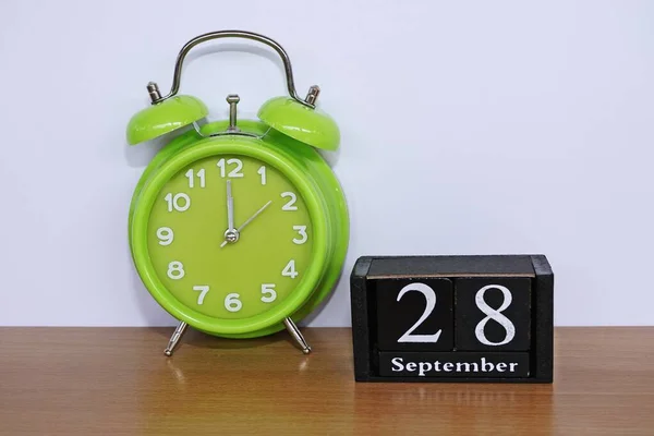 green alarm clock and cube calendar