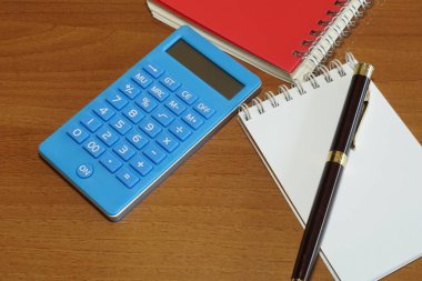 Masanın üzerinde kalem olan defter.