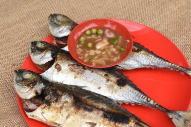 Tabağında sos olan ızgara balık.