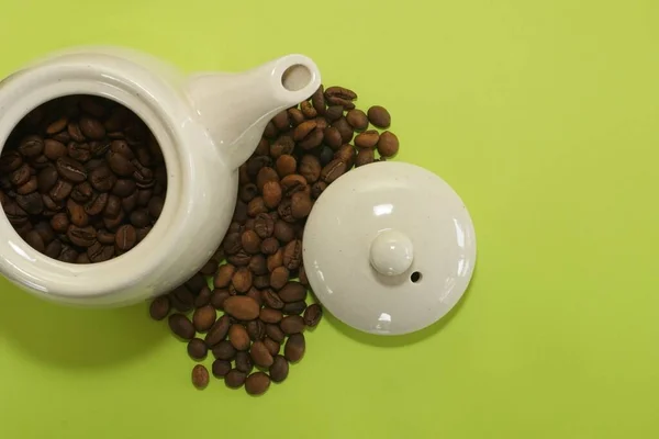 Kaffeebohnen Mit Keramikkanne Auf Grünem Hintergrund — Stockfoto