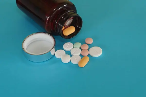Pillen Mit Behälter Auf Blauem Hintergrund — Stockfoto