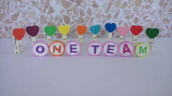 \'ONE TEAM\' word background made up from alphabet printed round shape eraser