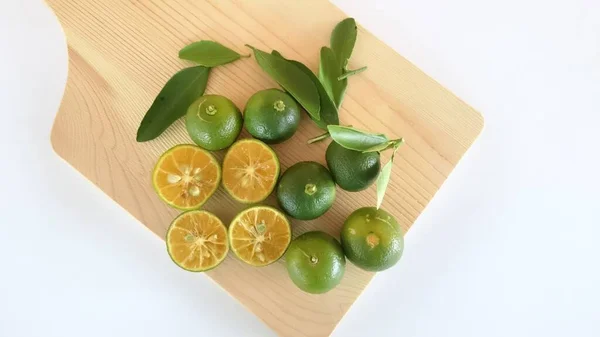 Kesme tahtasındaki Calamansi Lime. Güneydoğu Asya ülkelerinde daha çok Limau Kasturi olarak bilinen, Latin adı Mangifera casturi olan Borneolu tipik bir tropikal bitkidir.