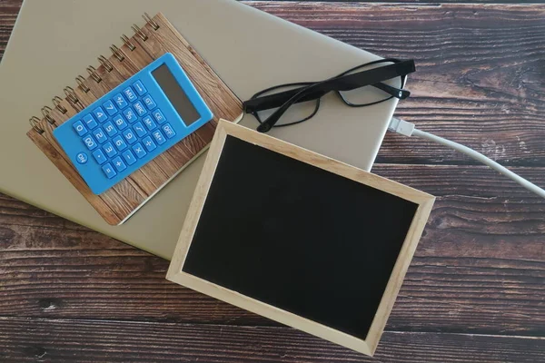 close up of laptop with internet cable and blue calculator on wooden background