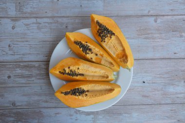 Ahşap arka planda papaya dilimleri