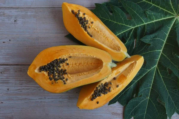 Rodajas Papaya Con Hoja Sobre Fondo Madera —  Fotos de Stock