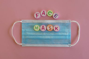 Pembe arka planda üç katmanlı yüz maskesi