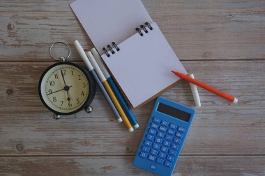 Masadaki çalar saat ve kırtasiye malzemeleri. Zaman yönetimi kavramı.