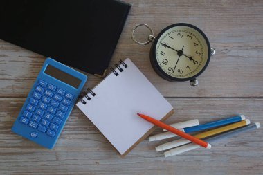 Masadaki çalar saat ve kırtasiye malzemeleri. Zaman yönetimi kavramı.