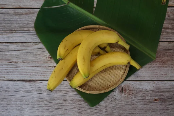 Bananenfrüchte Mit Blatt Auf Holzgrund — Stockfoto